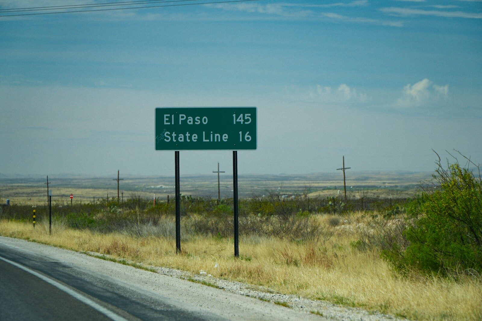 El paso and state line road sign in desert landscape
